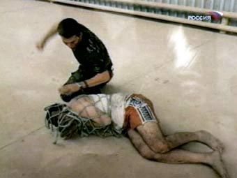 Издевательства над арестованным иракцем. Фотография, показанная в эфире телеканала "Россия"