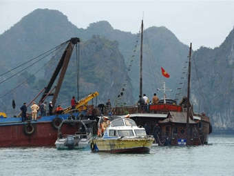Спасатели извлекают на поверхность затонувший вьетнамский катер. Фото ©AFP