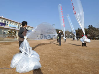 Южнокорейские активисты готовят шары с листовками. Фото ©AFP