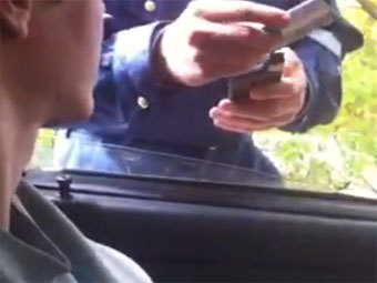 Полицейский считывает банковскую карту нарушителя. Скриншот с сайта YouTube