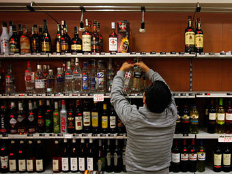 Владелец магазина снимает с прилавка алкогольную продукцию. Фото Reuters