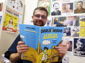 Редактор Charlie Hebdo с комиксом о жизни Мухаммада. Фото ©AFP