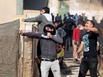 Палестинцы, бросающие камни в израильских военнослужащих. Фото ©AFP
